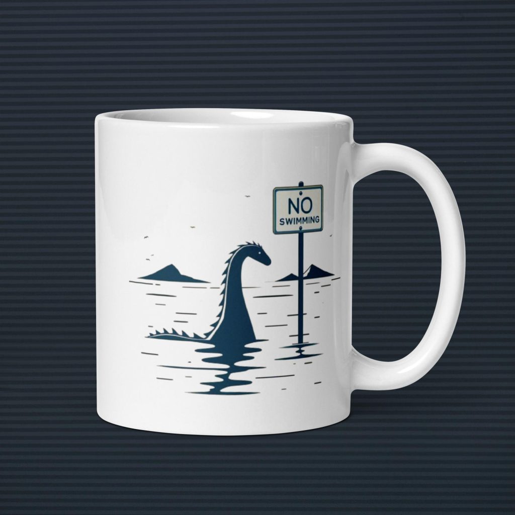 White coffee cup with the silhouette of Nessie, the Loch Ness Monster, next to a sign that says "No Swiming"